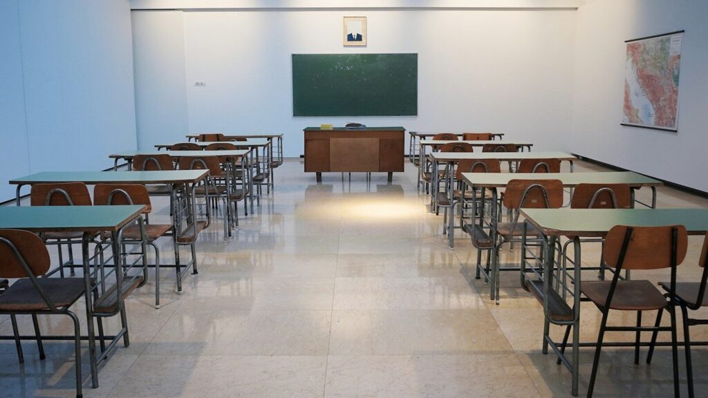 Photo by Ivan Aleksic empty classroom with desks and chalkboard